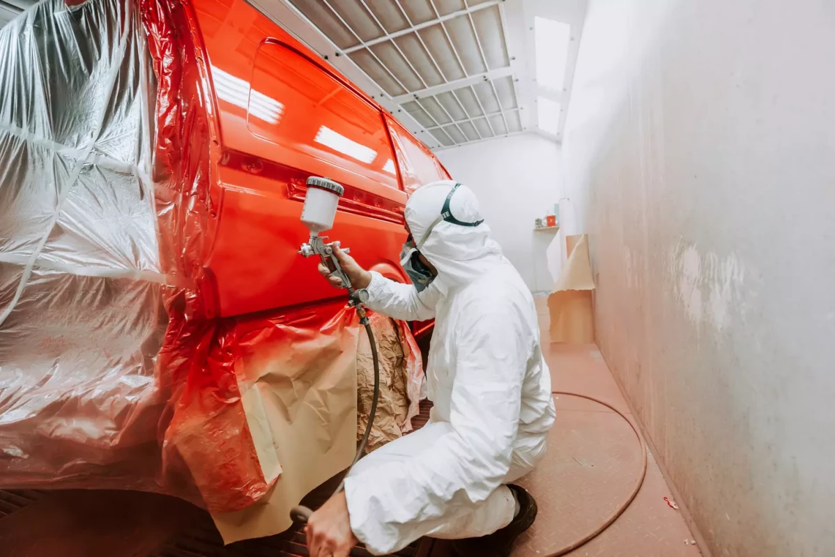 worker-painting-a-red-car-in-a-special-garage-wea-2024-09-19-11-34-28-utc